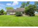 Backyard featuring a manicured lawn, mature trees, a patio, a deck, and a storage shed at 1013 Chapman Blvd, Greenfield, IN 46140