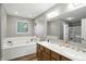 Bright bathroom featuring a large soaking tub and double sink vanity with wood cabinets at 1013 Chapman Blvd, Greenfield, IN 46140