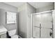 Bathroom featuring a shower with glass doors, toilet, and vanity with storage cabinet at 1013 Chapman Blvd, Greenfield, IN 46140