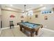 Basement billiard room with a pool table and decorative wall art on tiled floor at 1013 Chapman Blvd, Greenfield, IN 46140
