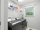 Functional laundry room with modern washer and dryer, shelving, and a window at 1013 Chapman Blvd, Greenfield, IN 46140