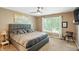 Comfortable bedroom features a queen sized bed, ceiling fan, and natural light at 1013 Chapman Blvd, Greenfield, IN 46140