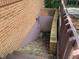 Exterior basement access with weathered steps and brick surround offers convenient entry at 106 N 300 W, Greenfield, IN 46140