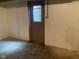 Unfinished basement area features cement floor and entry door with window at 106 N 300 W, Greenfield, IN 46140