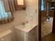 Modest bathroom with decorative wallpaper, white vanity and sink, with access to the hallway at 106 N 300 W, Greenfield, IN 46140