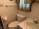 Cozy bathroom featuring a toilet, sink, and tiled walls with neutral tones and basic fixtures at 106 N 300 W, Greenfield, IN 46140