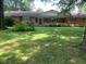 Ranch home featuring a brick facade, covered front porch, and a spacious, grassy front yard with mature trees at 106 N 300 W, Greenfield, IN 46140