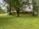 Charming single-story brick home on a lush, green lawn with mature trees providing shade at 106 N 300 W, Greenfield, IN 46140