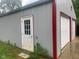 Metal clad outbuilding with single entry door and two garage doors at 106 N 300 W, Greenfield, IN 46140