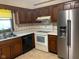 Functional kitchen with wood cabinets, stainless steel fridge, and standard appliances at 106 N 300 W, Greenfield, IN 46140
