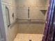 Roll-in shower with tile surround, grab bars, and accessible features, ensuring safety and convenience at 106 N 300 W, Greenfield, IN 46140