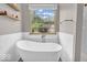 Bright bathroom featuring a modern soaking tub under a window and glass enclosed shower at 11123 Garrick St, Fishers, IN 46038