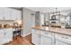 Bright eat-in kitchen features white cabinetry, granite counters, hardwood floors, and built in desk at 11123 Garrick St, Fishers, IN 46038