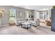 Comfortable living room featuring plush carpeting, large windows, and neutral gray walls at 11123 Garrick St, Fishers, IN 46038