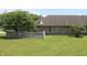 Backyard with grass, brick exterior, small fence, and mature tree at 126 Old Farm Rd, Danville, IN 46122