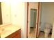 Neutral bathroom featuring a wood vanity with a solid surface top, a mirror and toilet at 126 Old Farm Rd, Danville, IN 46122