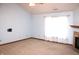 Bright living room with neutral carpet, a ceiling fan, fireplace and natural light streaming through the window at 126 Old Farm Rd, Danville, IN 46122