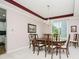 Formal dining room with a chandelier, dark wood table, and views to an adjacent room at 13214 Dunwoody Ln, Carmel, IN 46033