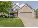 Charming two-story home featuring blue shutters, a covered front porch, and a well-manicured lawn at 13214 Dunwoody Ln, Carmel, IN 46033
