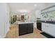 Bright kitchen with center island looking into the living room with a fireplace and lots of light at 13214 Dunwoody Ln, Carmel, IN 46033
