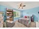 Bright bedroom featuring a large window, ceiling fan, and built-in shelving at 13470 Shakamac Dr, Carmel, IN 46032