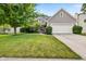 Charming two-story home featuring a well-manicured lawn, mature trees, and a two-car garage at 13470 Shakamac Dr, Carmel, IN 46032