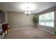 Neutral dining room featuring tan carpet, a modern chandelier, and ample natural light from a large window at 13884 Wendessa Dr, Fishers, IN 46038