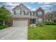 Charming two-story home featuring a brick and vinyl exterior, attached two-car garage, and well-manicured lawn at 13884 Wendessa Dr, Fishers, IN 46038