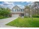 Charming two-story home featuring a brick and vinyl exterior, attached two-car garage, and well-manicured lawn at 13884 Wendessa Dr, Fishers, IN 46038