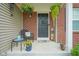 Cozy front porch featuring a wicker chair, decorative pillows, hanging flower baskets, and a 'Home Sweet Home' sign at 13884 Wendessa Dr, Fishers, IN 46038
