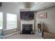 Cozy living room corner featuring a fireplace, a built-in bookshelf, and a large window with natural light at 13884 Wendessa Dr, Fishers, IN 46038
