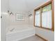 Relaxing bathroom with a soaking tub, sconce lighting, and a picture window at 1393 Stoney Creek Cir, Carmel, IN 46032