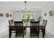 Formal dining room with large window, modern chandelier and seating for six at 1393 Stoney Creek Cir, Carmel, IN 46032