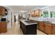 Open kitchen featuring a center island with cooktop, bright cabinetry and wood flooring at 1393 Stoney Creek Cir, Carmel, IN 46032