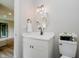 Cozy powder room featuring a decorative mirror, white vanity and a modern light fixture at 1540 Roanoke Dr, Zionsville, IN 46077
