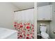 Well-lit bathroom featuring floral shower curtain, white vanity and cabinet for convenient storage at 1540 Roanoke Dr, Zionsville, IN 46077