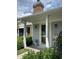 Inviting front entrance with stone accents, a covered porch, and beautiful landscaping with vibrant greenery at 1540 Roanoke Dr, Zionsville, IN 46077