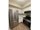 Eat-in kitchen with stainless steel appliances, white cabinets, and hardwood floors at 1540 Roanoke Dr, Zionsville, IN 46077