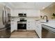 Full kitchen view showcasing stainless appliances, white cabinets, quartz countertops, and eat-in space at 1540 Roanoke Dr, Zionsville, IN 46077