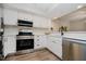 Updated kitchen boasts stainless steel appliances, white cabinetry, quartz countertops, and modern fixtures at 1540 Roanoke Dr, Zionsville, IN 46077