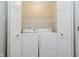 Bright laundry room features a washer, dryer, white folding doors and overhead shelving at 1540 Roanoke Dr, Zionsville, IN 46077