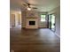 Spacious living room featuring hardwood floors, a ceiling fan, and a cozy brick fireplace at 1540 Roanoke Dr, Zionsville, IN 46077