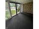 Enclosed brick patio with gray carpeting and sliding glass door to backyard and home interior at 1540 Roanoke Dr, Zionsville, IN 46077