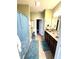 Well-lit bathroom with double sinks, ceramic tile flooring, and a coordinating blue shower curtain and rugs at 1688 Magnolia Dr, Greenwood, IN 46143