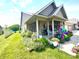 Well-maintained front yard features a colorful flower bed and inviting porch, enhancing the home's exterior at 1688 Magnolia Dr, Greenwood, IN 46143