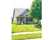 Inviting home featuring a covered front porch with attractive landscaping and a lush green lawn at 1688 Magnolia Dr, Greenwood, IN 46143
