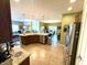 Open-concept kitchen featuring tile floors, granite counters, stainless appliances, and adjacent living and dining areas at 1688 Magnolia Dr, Greenwood, IN 46143