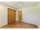 Bedroom featuring a ceiling fan, hardwood floors, and light floral wallpaper at 1841 Shady Ln, Martinsville, IN 46151