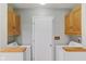 Laundry room featuring wood cabinets, laundry machines, and gray walls at 1841 Shady Ln, Martinsville, IN 46151