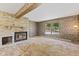 Spacious living room with stone fireplace, large window, and vintage wallpaper detail at 1841 Shady Ln, Martinsville, IN 46151